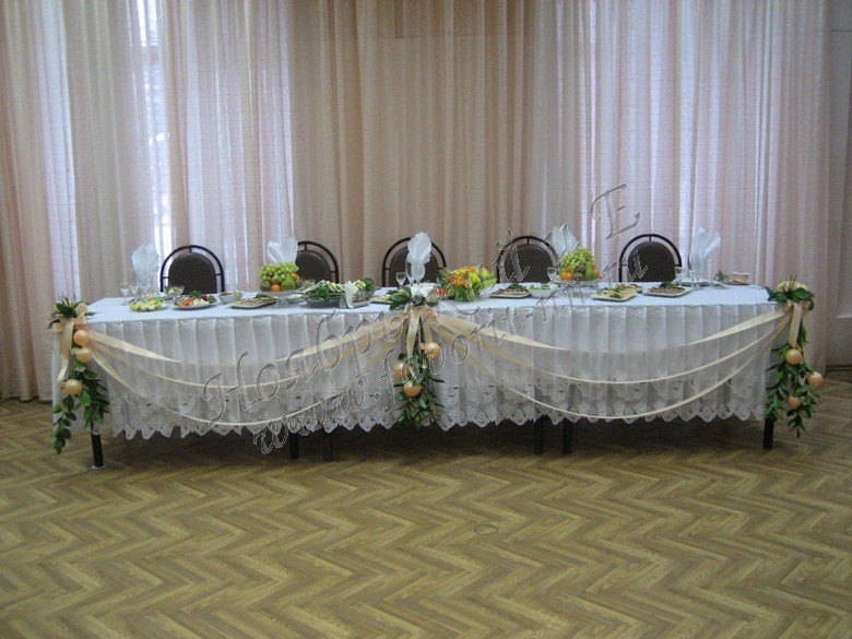 Свадебное украшение главного стола букетами из живых цветов и атласных лент